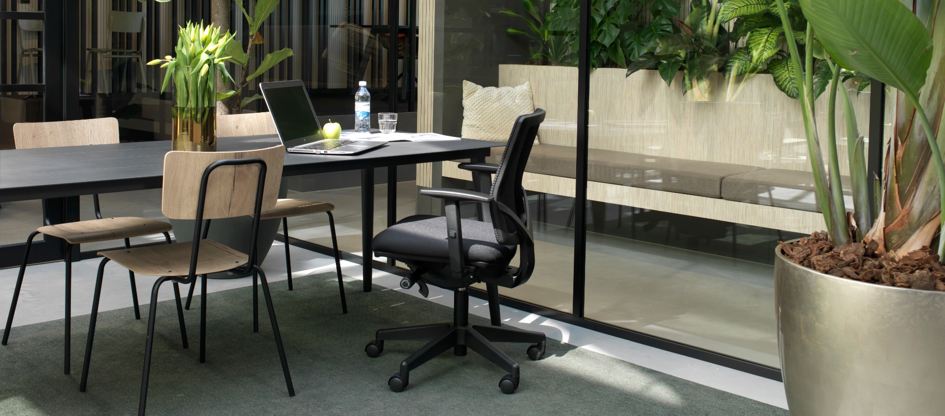 Werkplekken met zwarte bureaustoelen